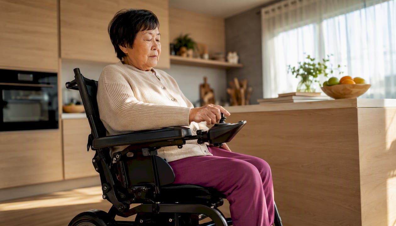 Elderly woman operating foldable electric wheelchair indoors