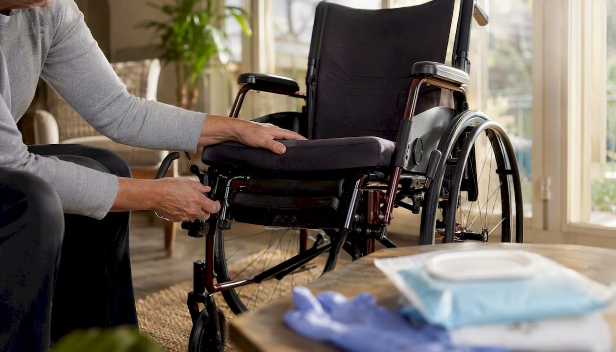 Hands adjusting wheelchair armrest