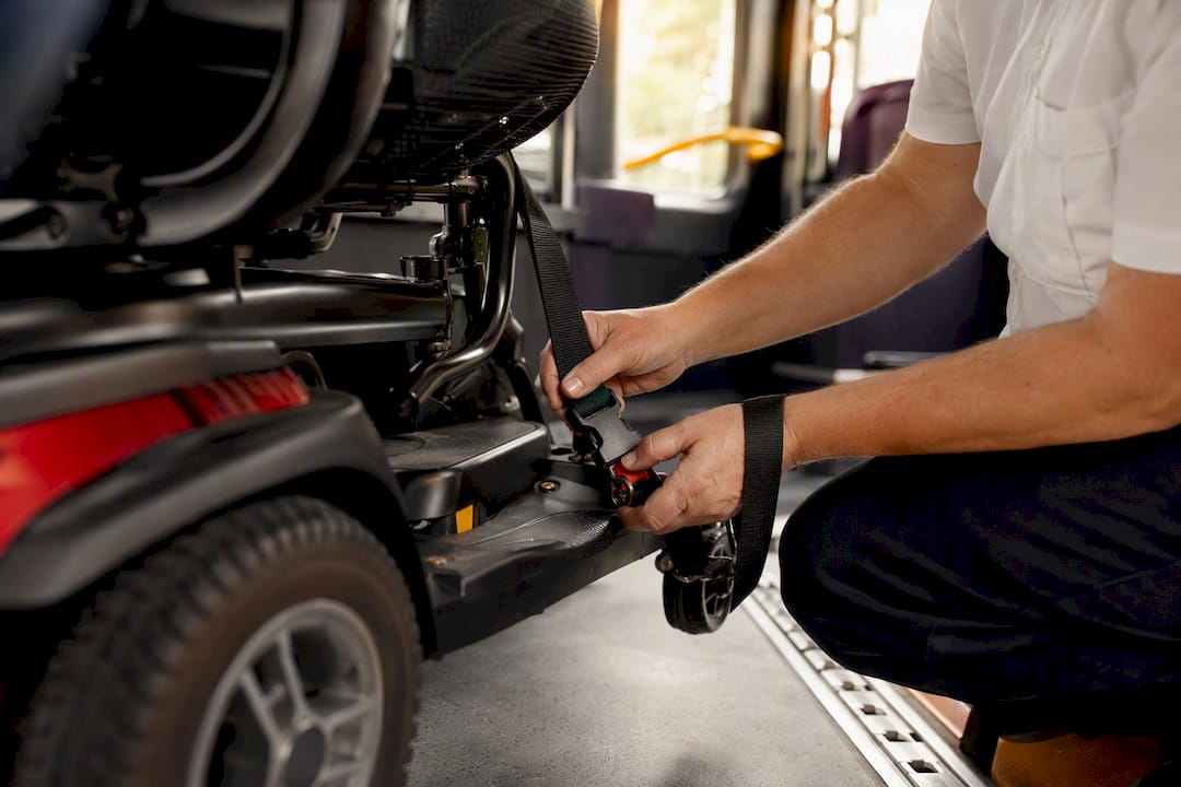 Driver fastening scooter tie-down straps inside vehicle