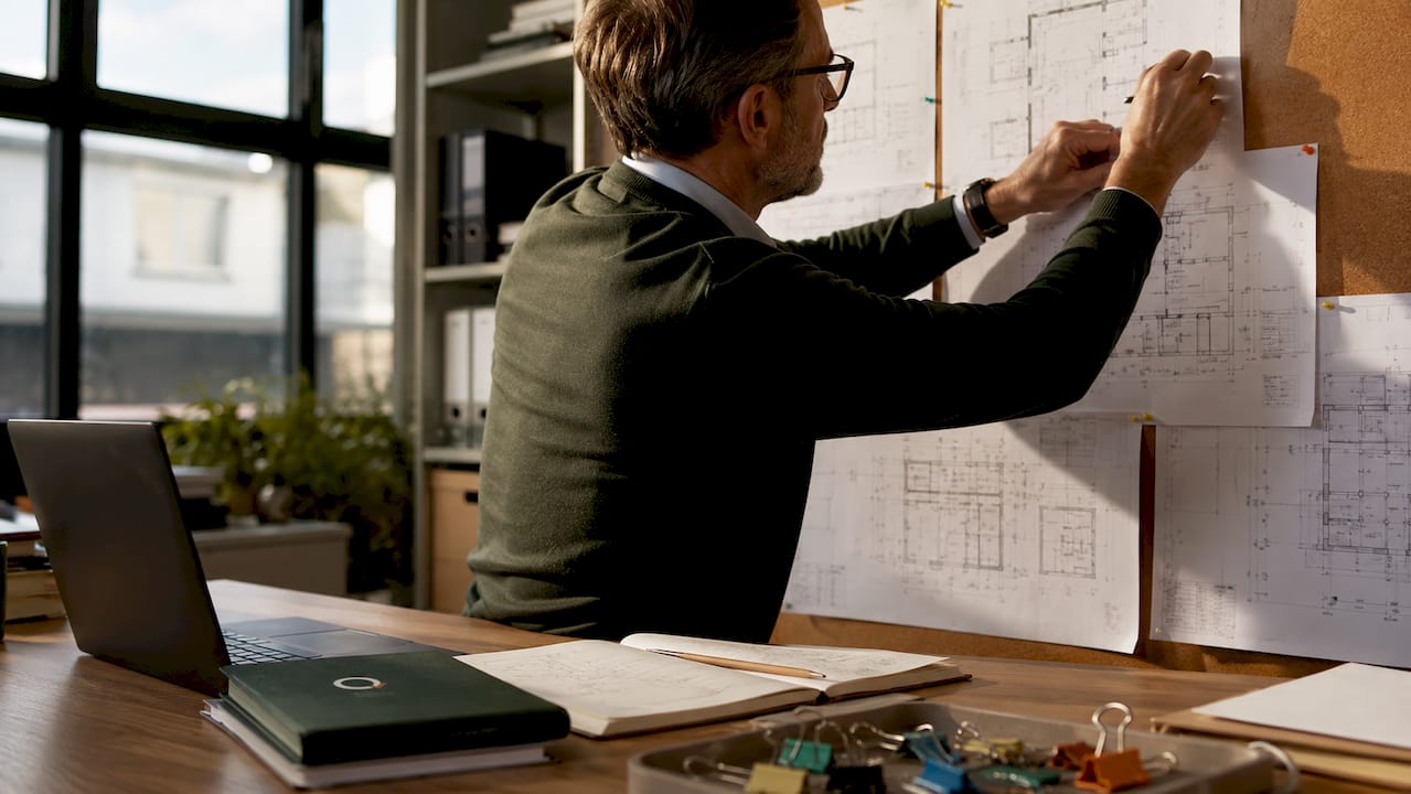 Surveyor hands organizing cost plan documents overhead