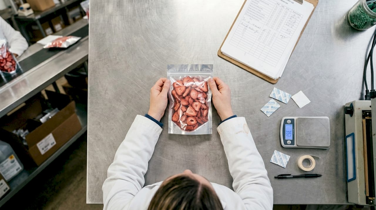 Technician inspecting sealed snack packaging