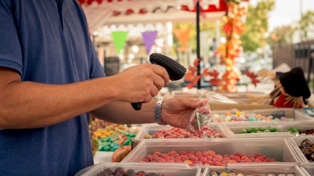 Hands scanning bulk candy inventory bins