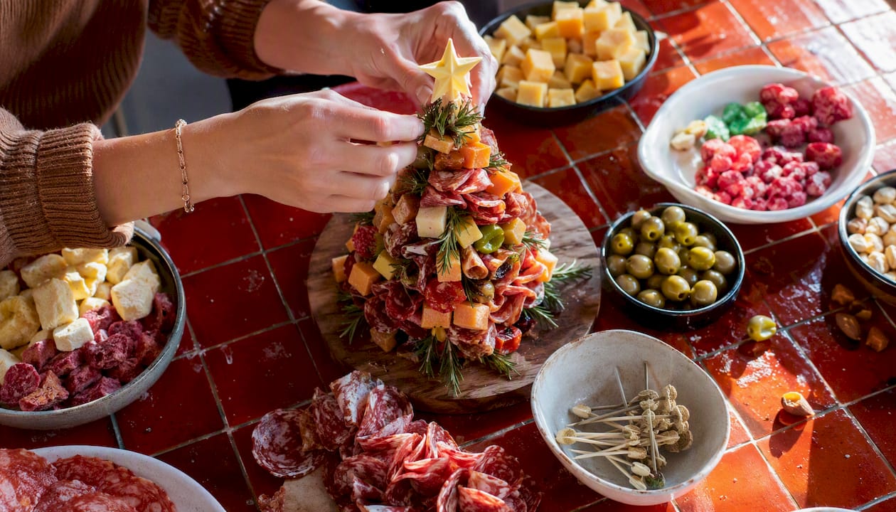 Hands building charcuterie tree kit on counter