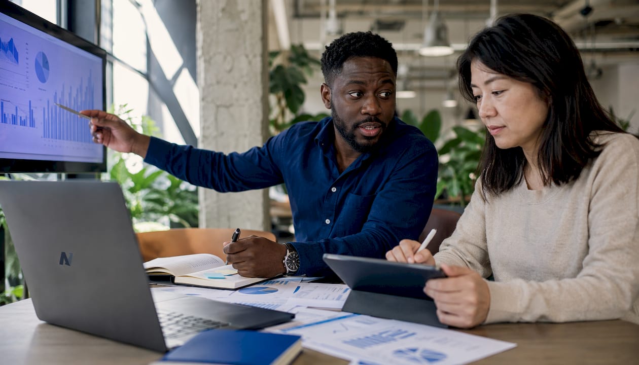 Two professionals reviewing monthly financial reports
