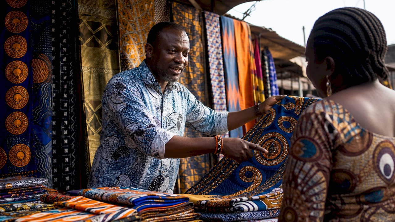 Retailer examining premium traditional fabrics in market