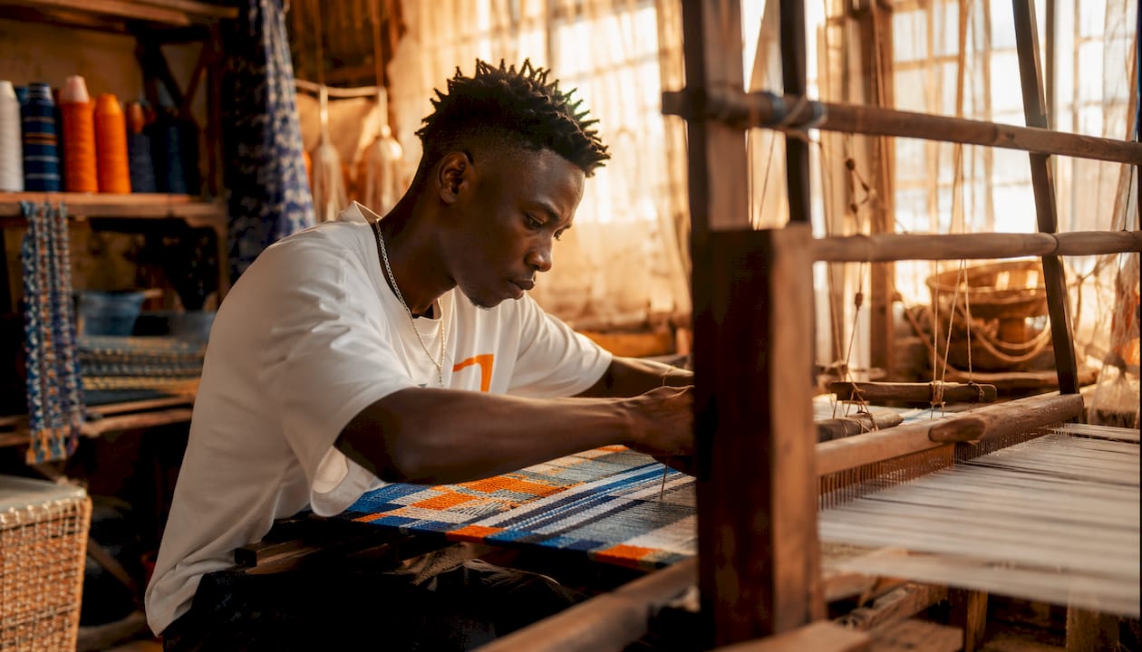 Artisan weaving traditional fabric in workshop