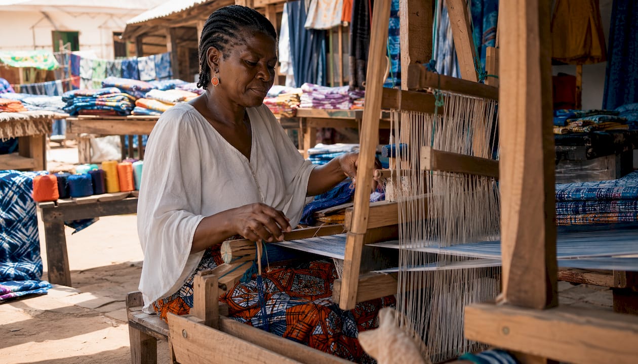 Artisan weaving hand-dyed textile on loom