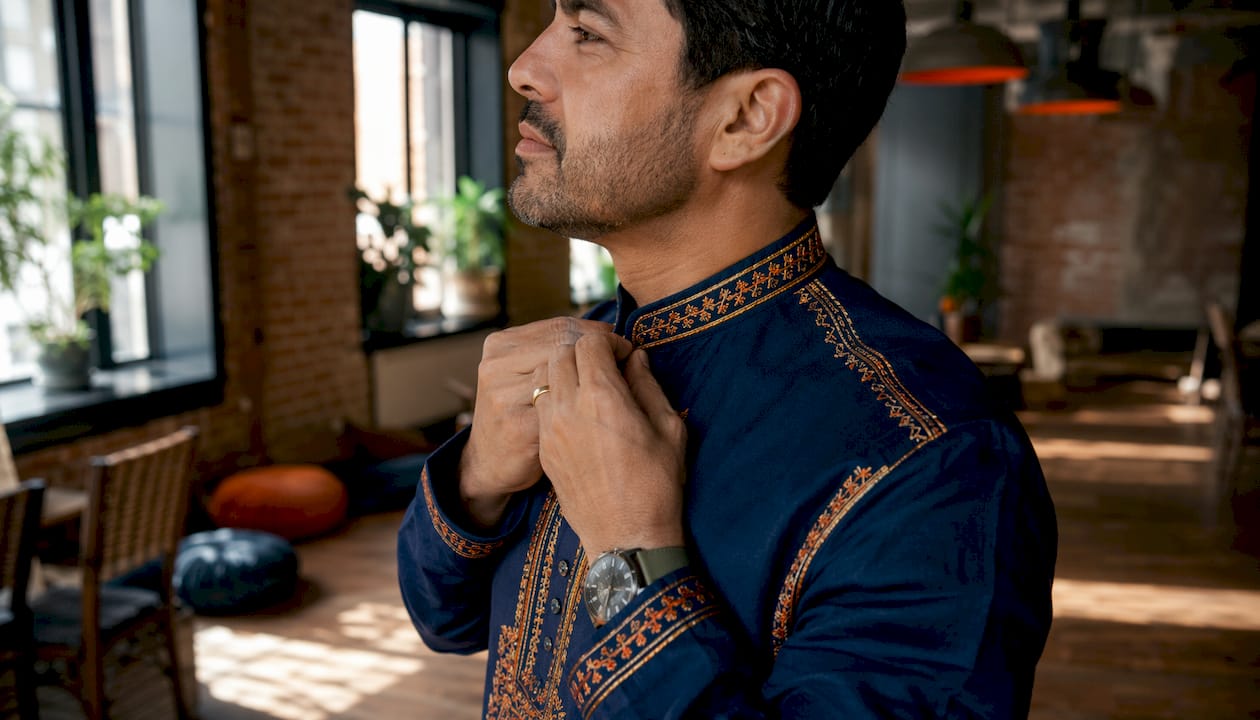 Man adjusting dashiki collar in meeting room
