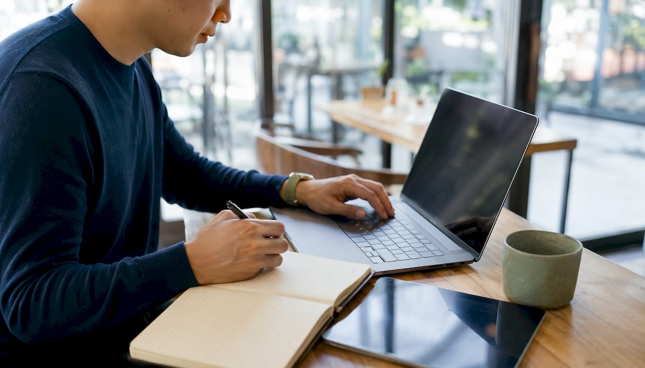 Hands on keyboard and pen with market notes
