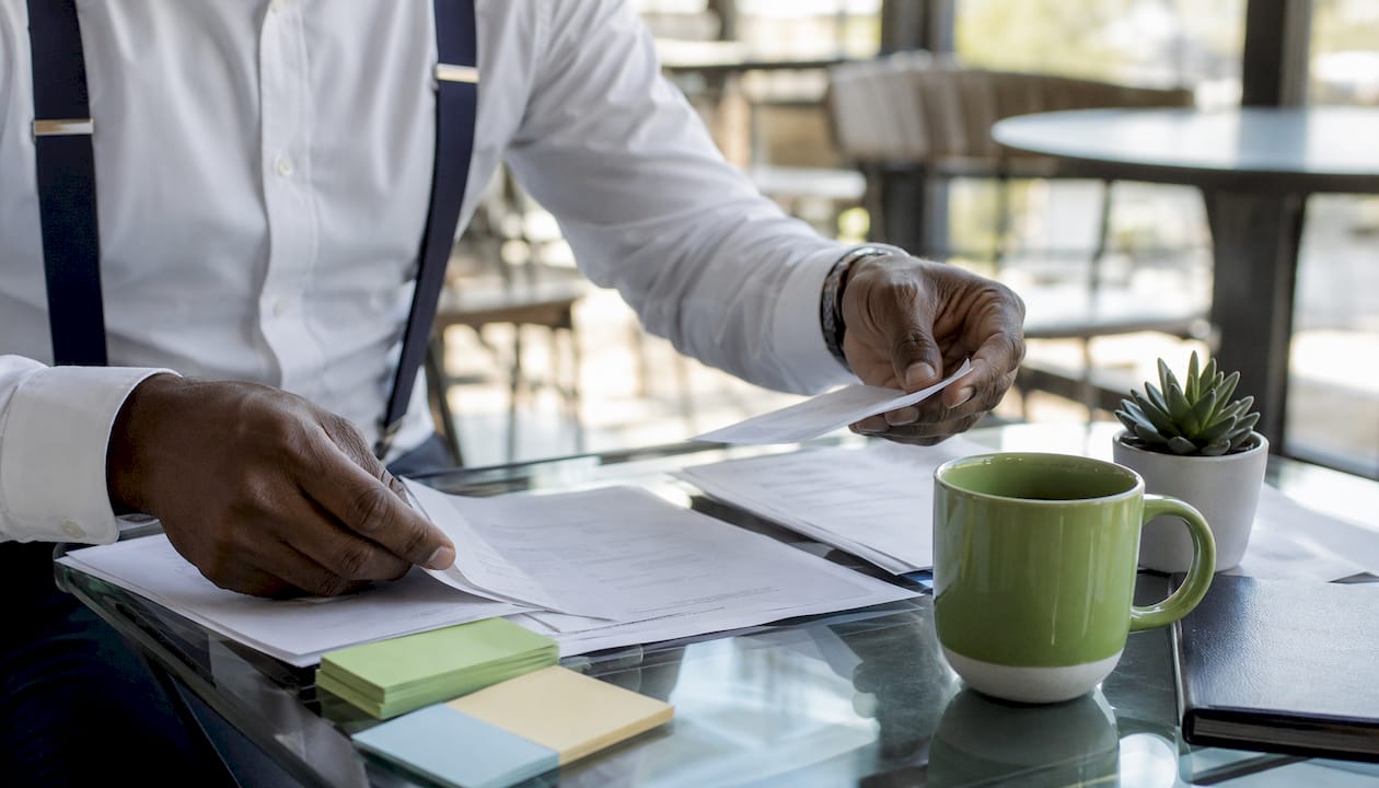 Hands sorting business documents on desk