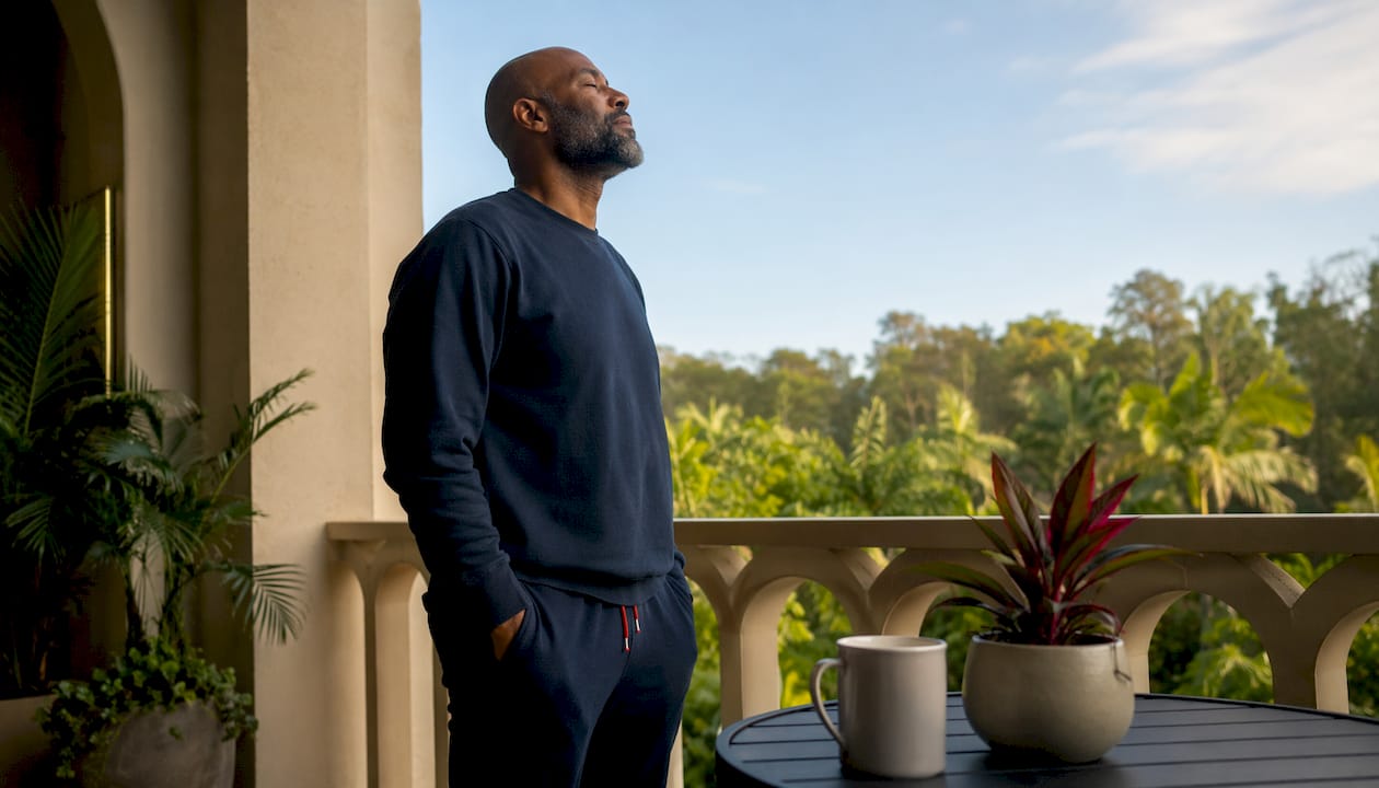 Man stretching by morning window after waking
