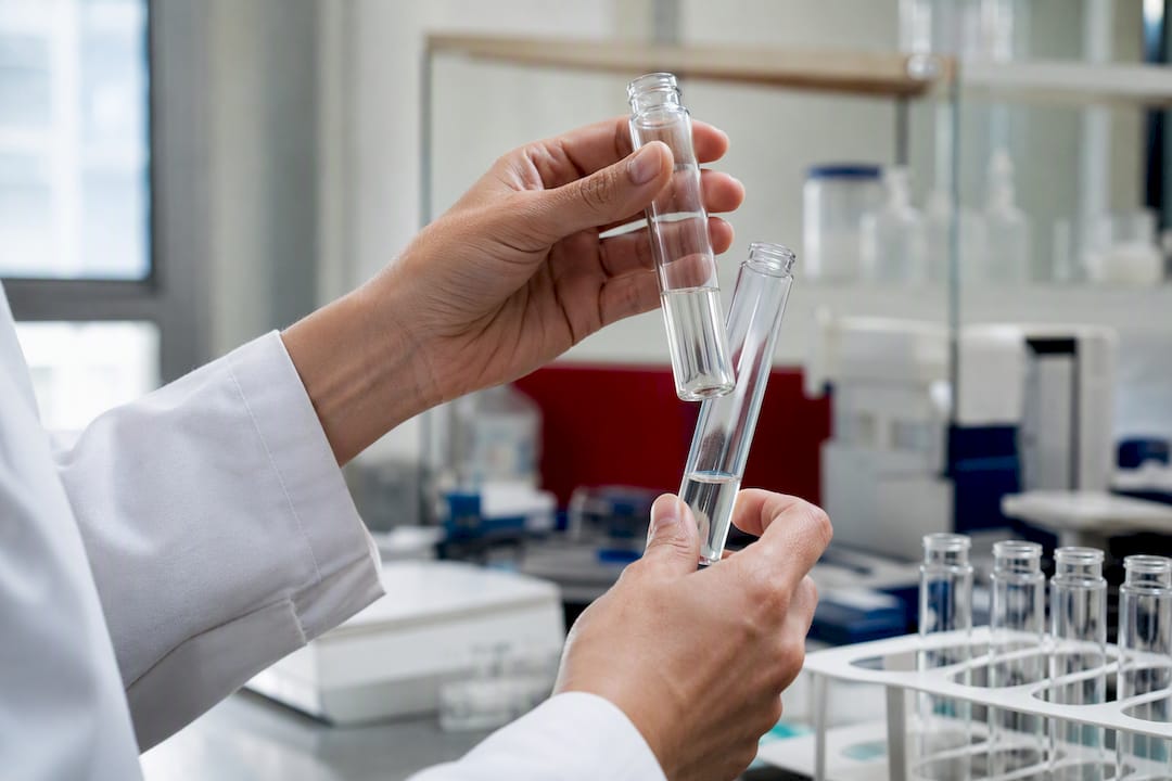 Laboratory hands handling collagen peptide test tubes