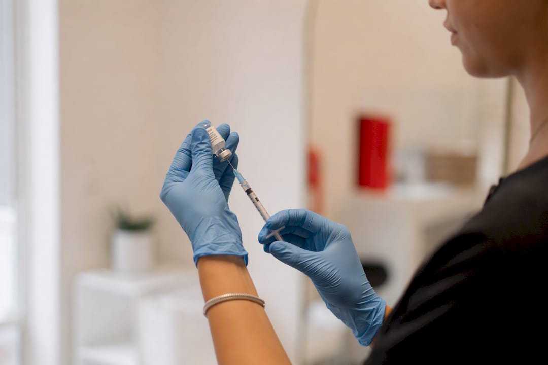 Hands drawing injectable filler syringe