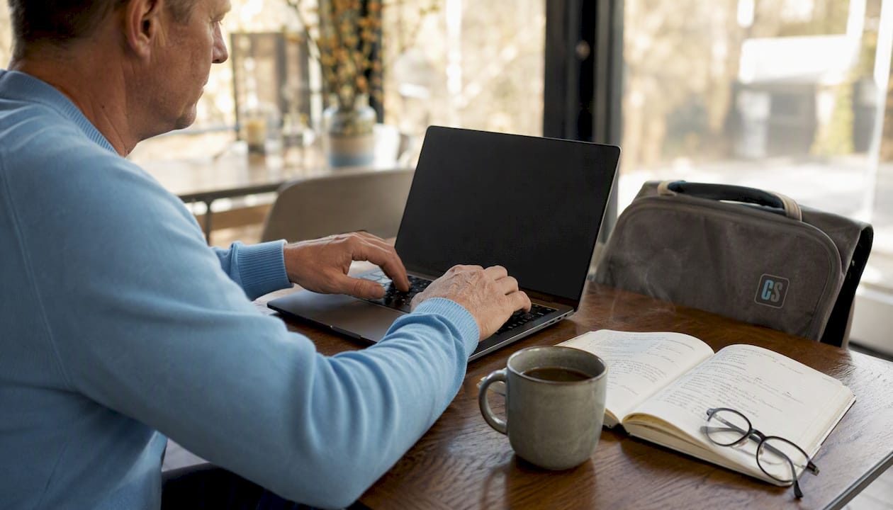 Close-up of hands typing and notes on email subscription setup