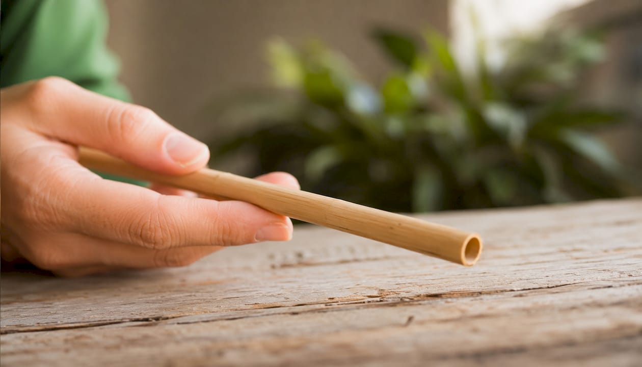 Detailopname van een duurzame bamboe rietje op een houten tafel