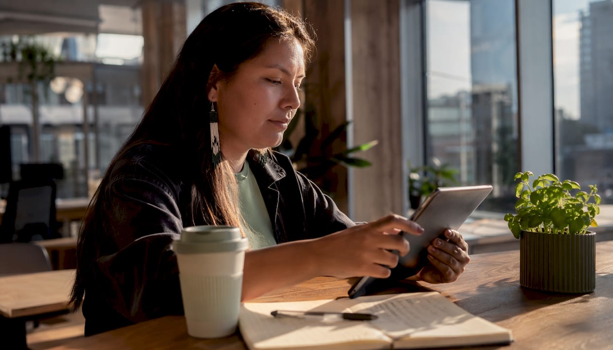 Woman using tablet for social media marketing in café