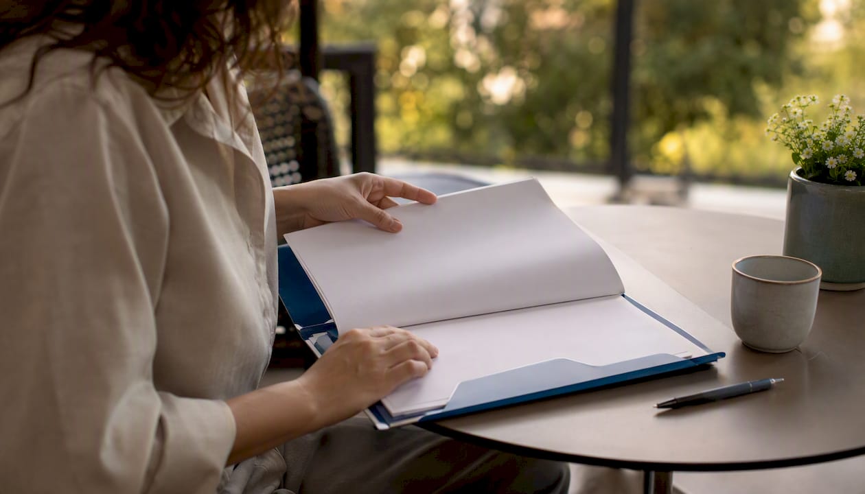 Hands organizing blank contract papers at table