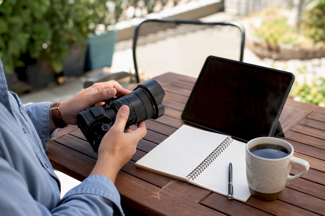 Hands adjusting camera lens on creative workspace