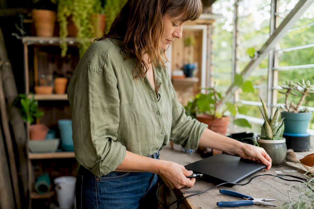 Hands connecting charger cable in small business setting