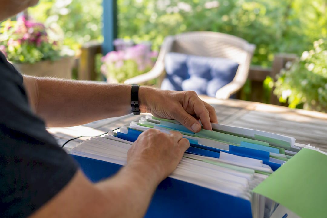 Hands sorting postal code folders on office desk