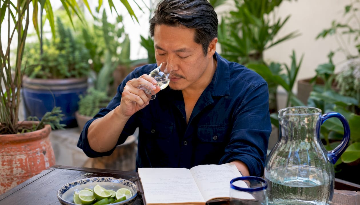 Man smelling blanco tequila in minimalist kitchen