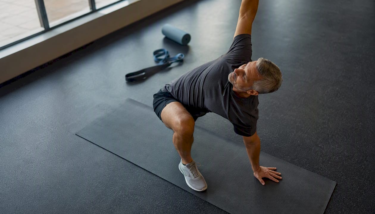 Man doing warm-up lunges in gym