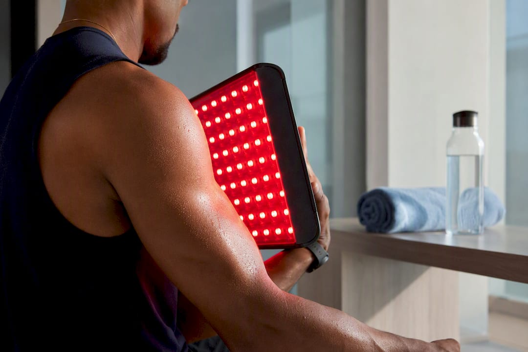 Athlete receiving red light therapy on shoulder post-workout