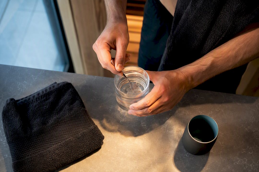 Hands stirring salt into water after sauna
