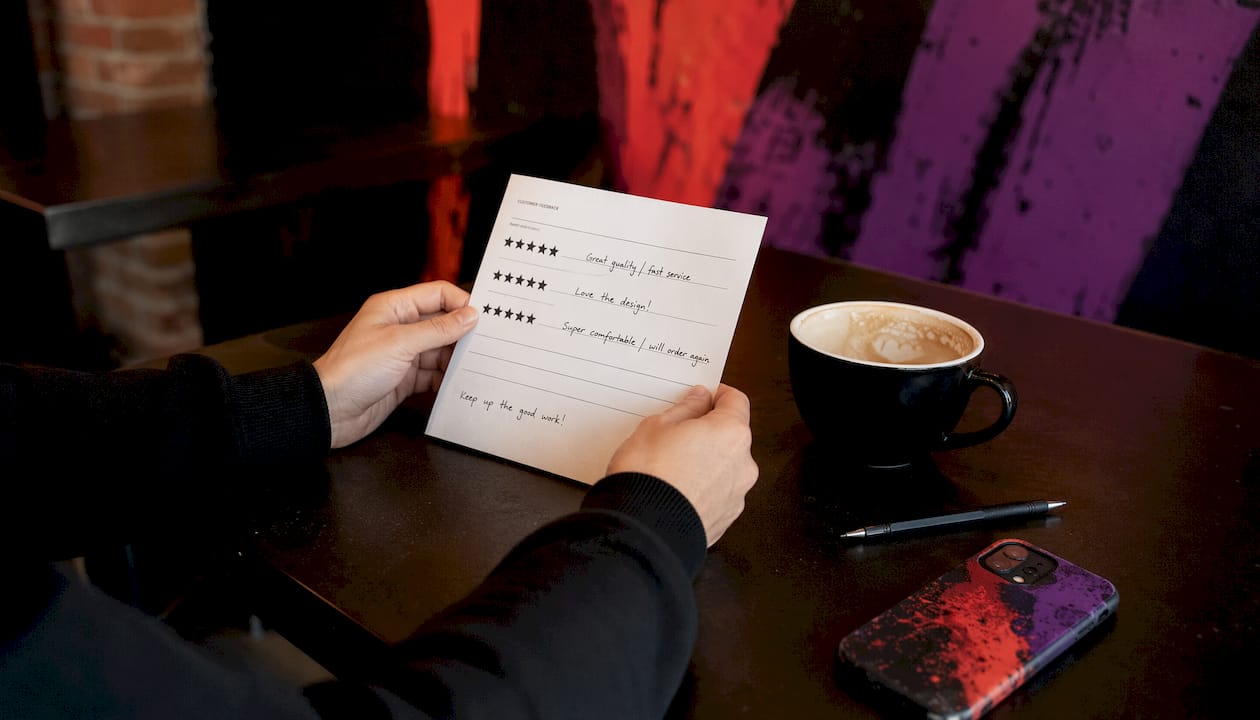 Hands holding customer review form on branded apparel