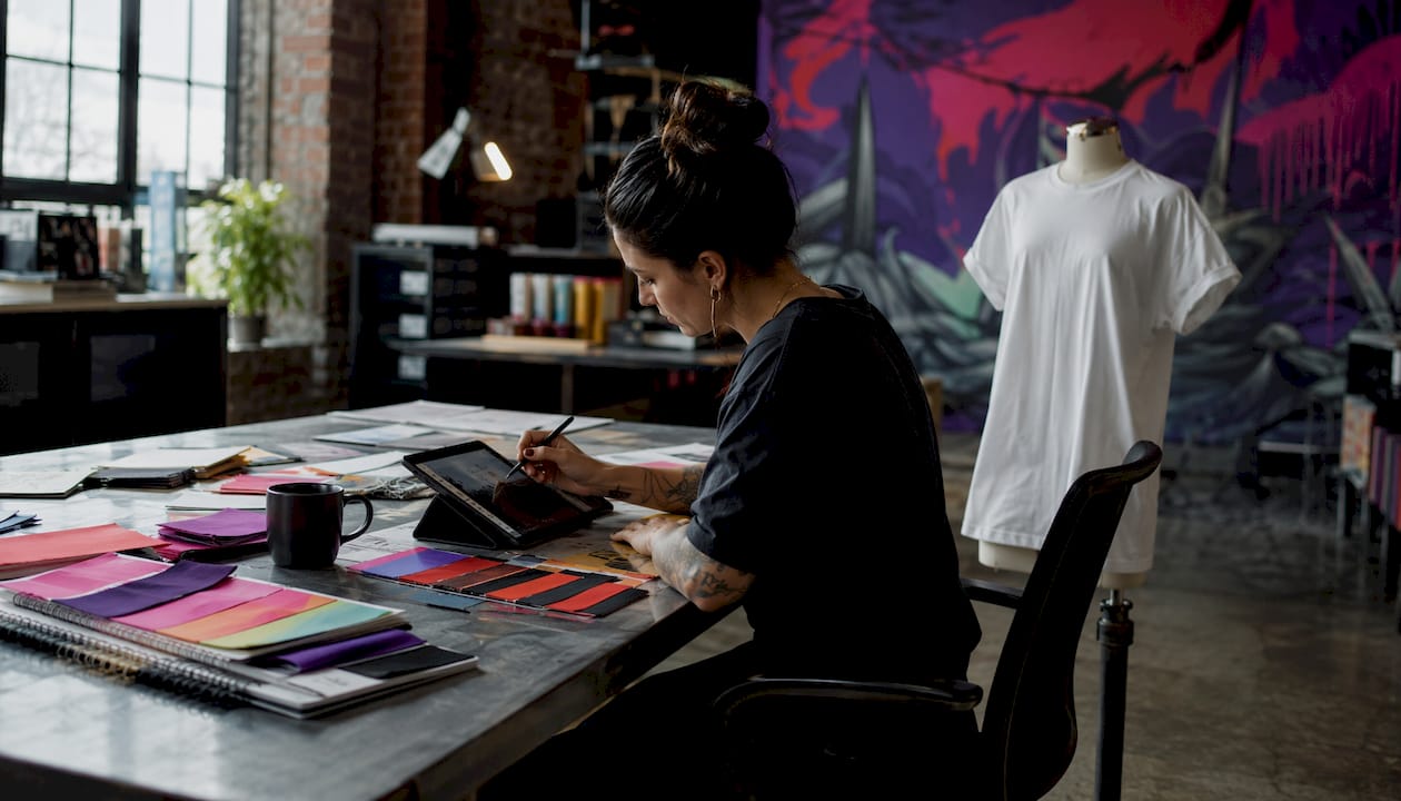 Designer customizing TV show tee design at home studio