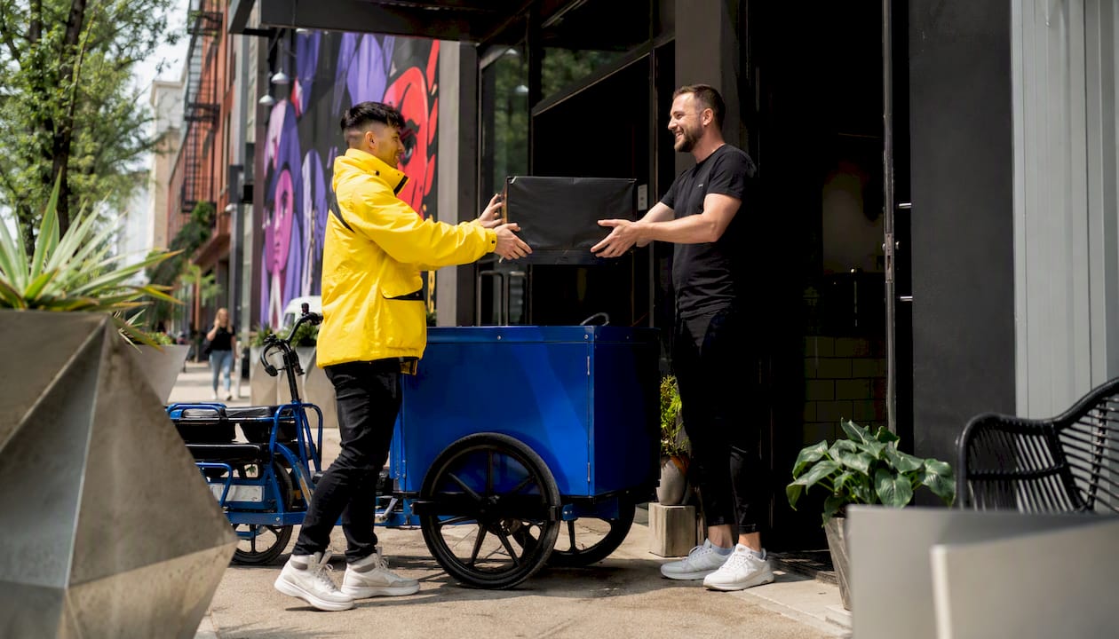 Courier handing oversized package to local business owner