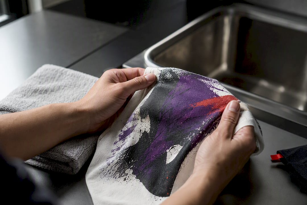 Hands inspecting a washed printed fabric sample
