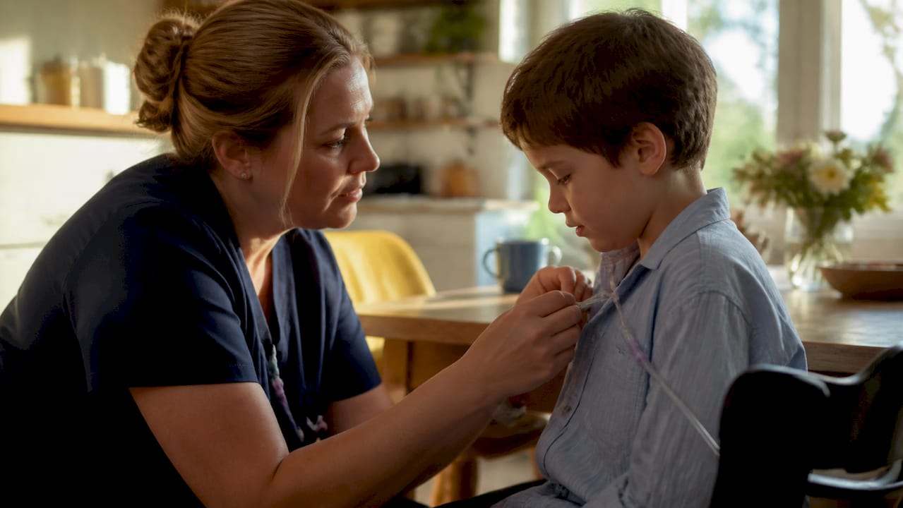 Nurse’s hands adjusting pediatric medical tubing at home