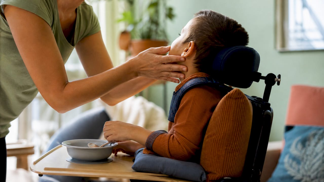 Caregiver gently supporting child during feeding
