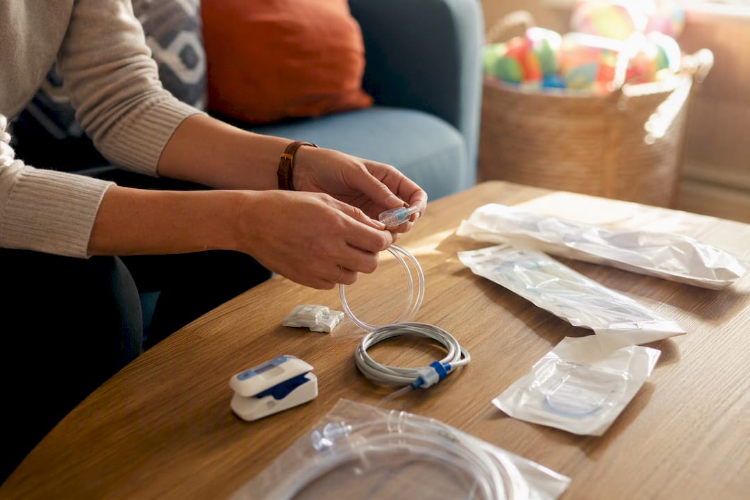 Hands arranging pediatric cardiac home nursing supplies