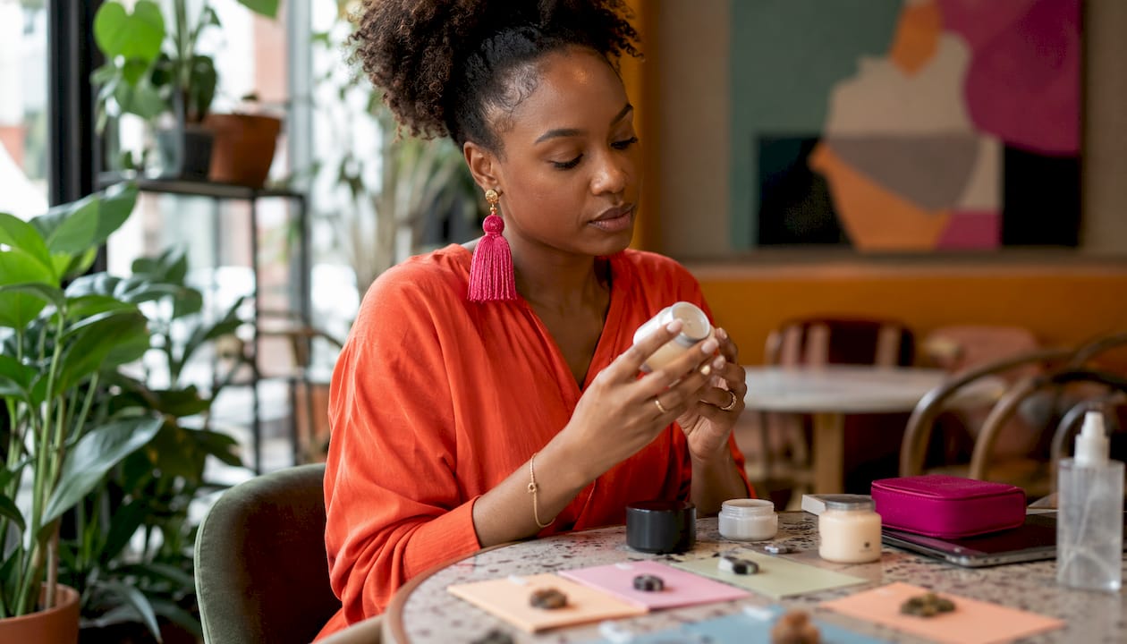 Hands examining skincare product ingredients