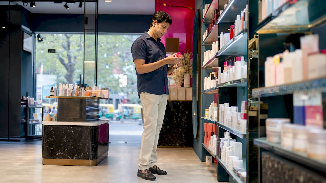 Man examining beauty products in store