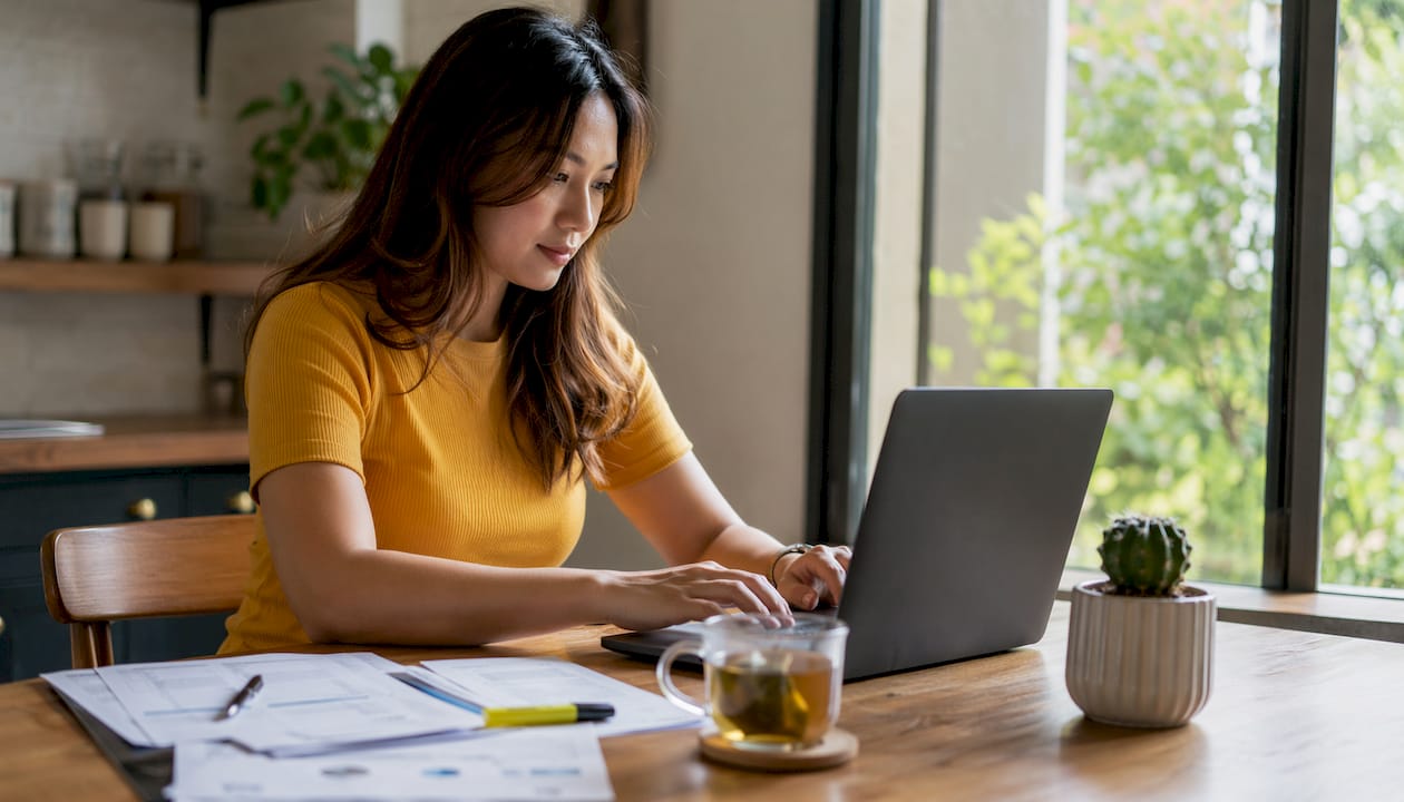 Hands typing annual return filing on laptop