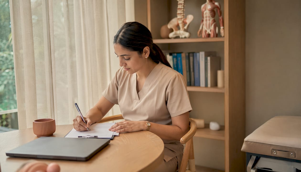 Physiotherapist preparing postnatal assessment notes