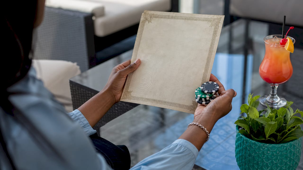Hands holding ownership certificate and poker chips