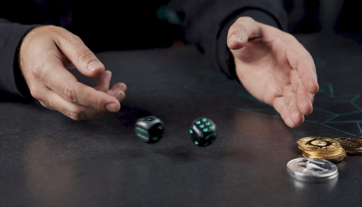 Hands rolling dice on dark gaming table