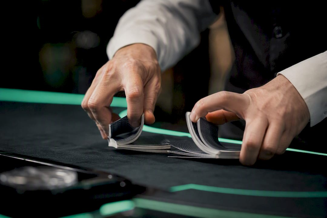 Dealer's hands shuffling cards at blackjack table