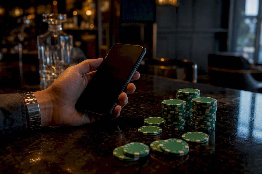 Hand holding smartphone near poker chips