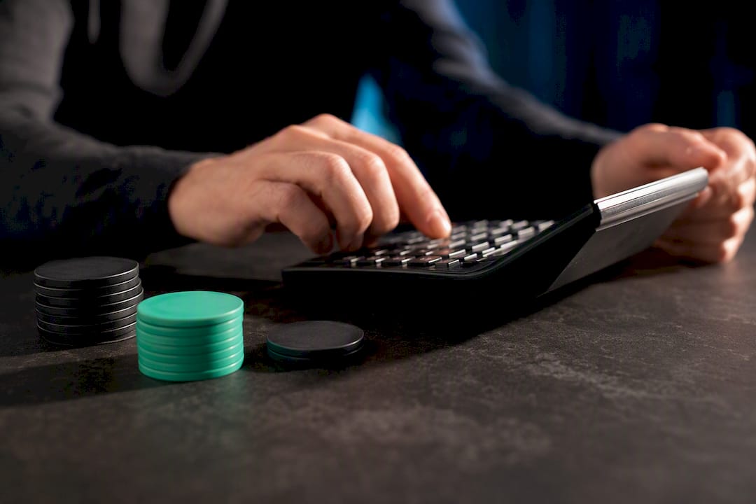 Hands calculating a measured betting stake