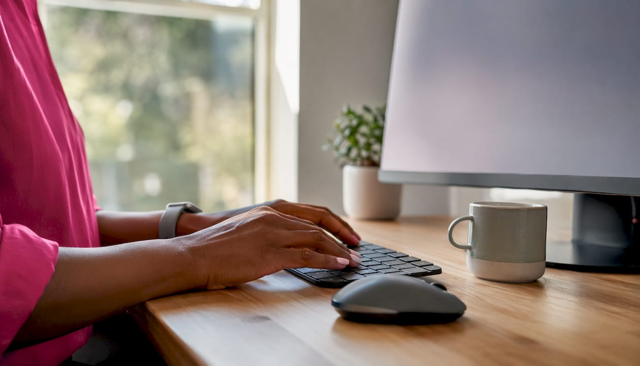 Hands typing on keyboard at tech workspace