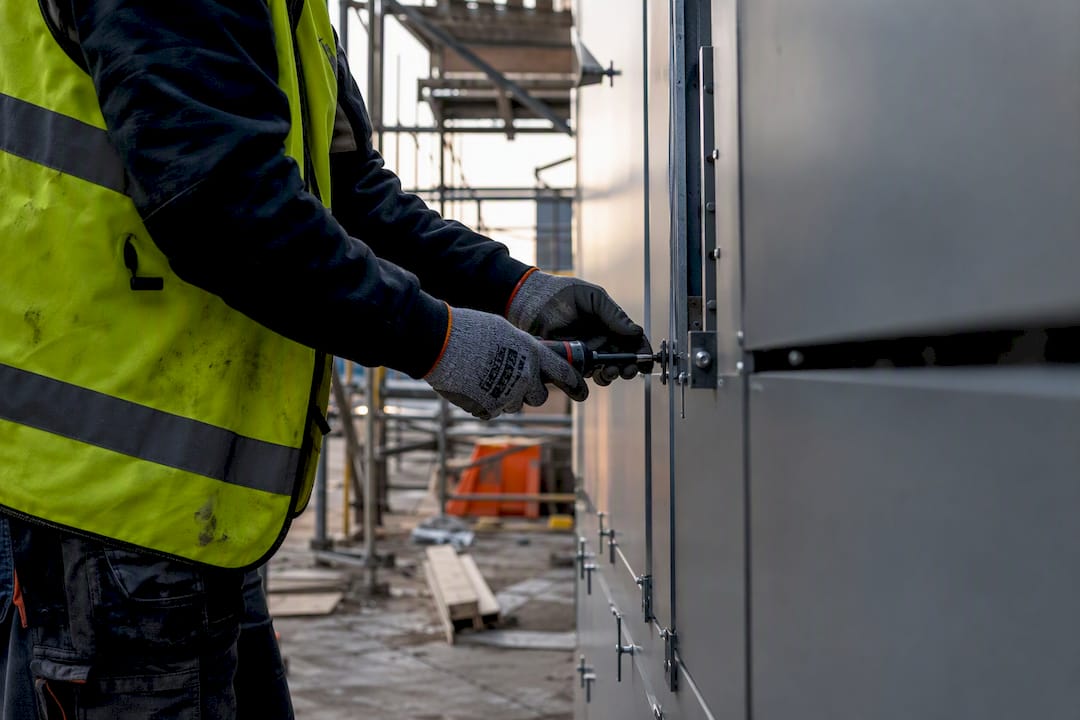 Construction worker fastening metal panel