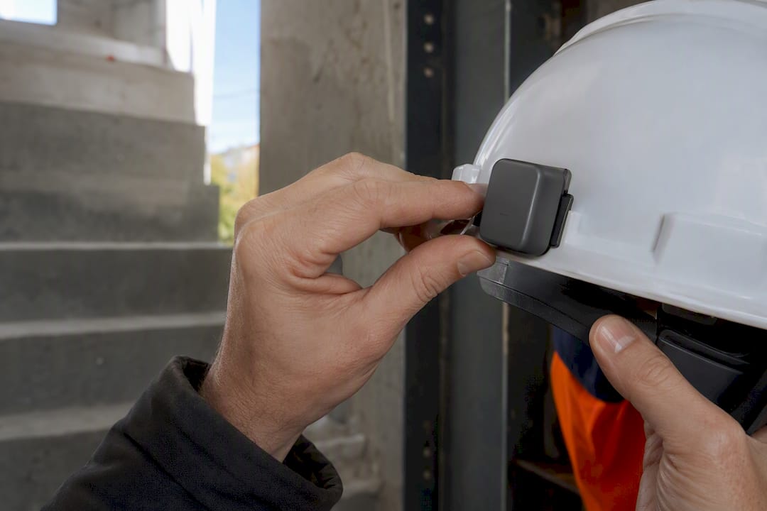 Worker attaching a sensor to a hard hat