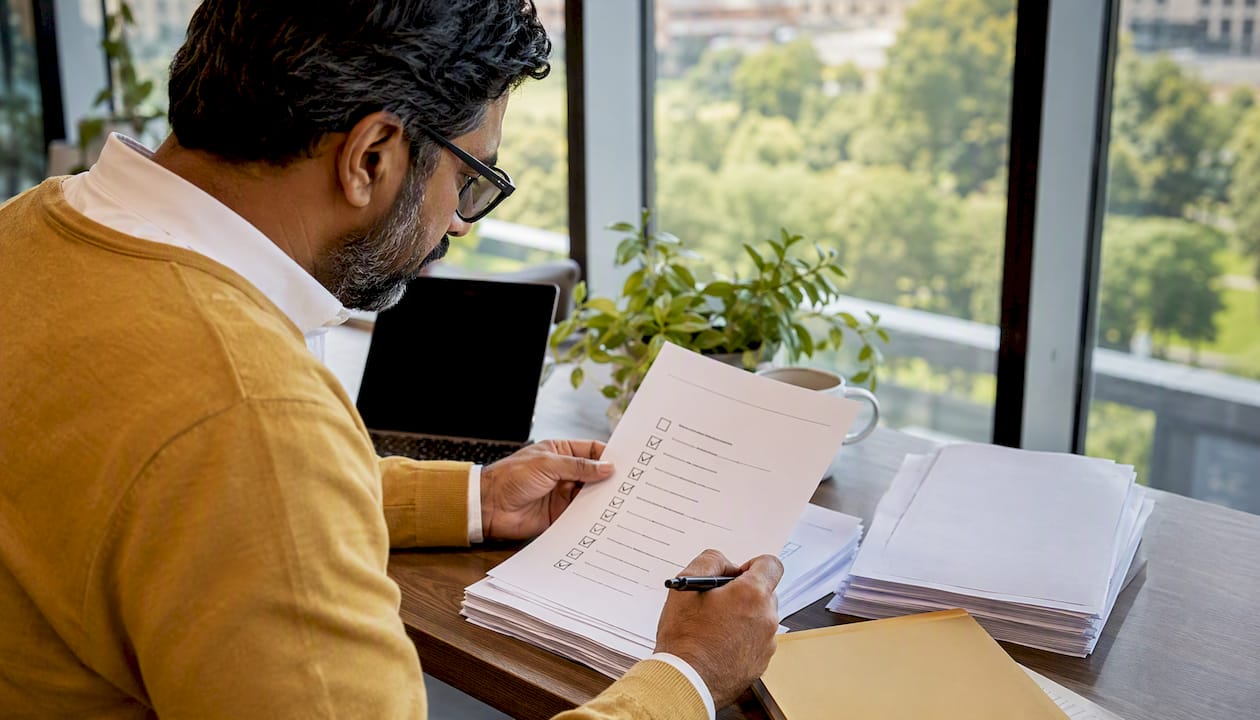 Overhead of man reviewing SEIS checklist papers