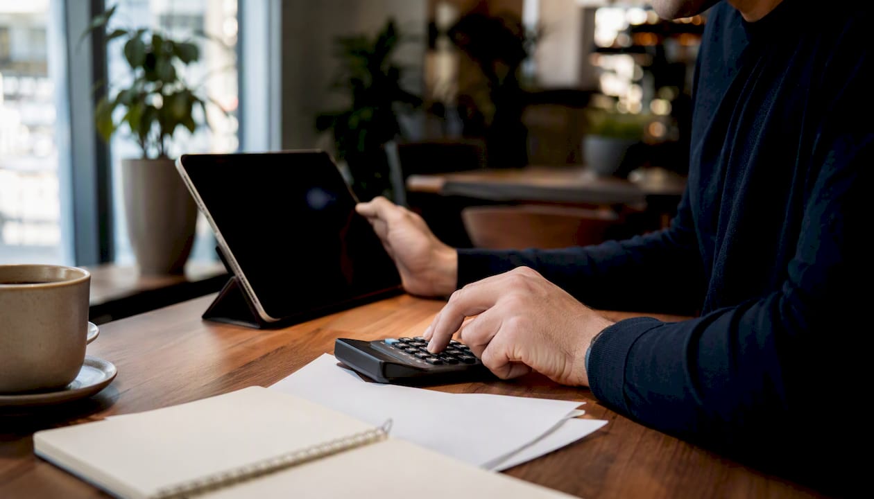 Founder calculating SaaS KPIs on desk