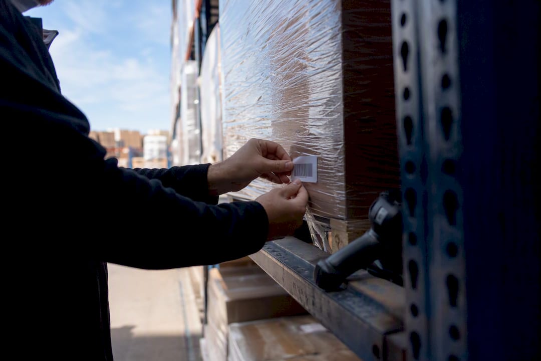 Hands tagging stock in warehouse